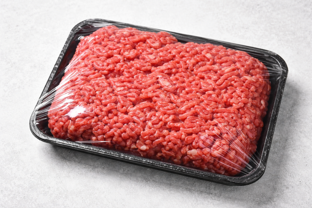 ground beef package plastic wrapped on kitchen counter