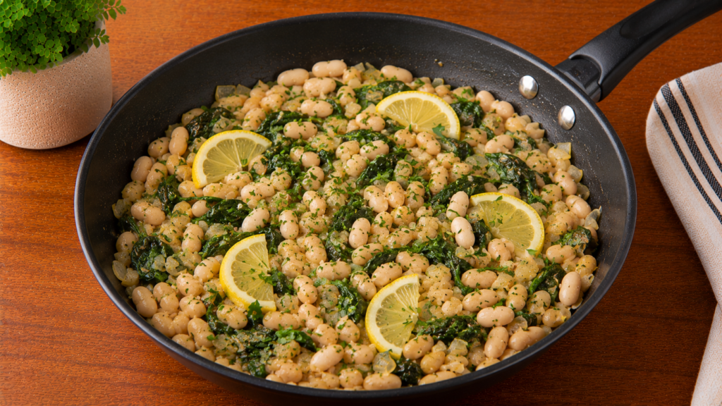Lemon herb white bean skillet with white beans, fresh herbs, and vegetables served in a skillet on a wooden countertop.